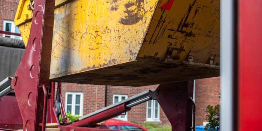 Big Yellow rubbish skip near the house. Rubbish removal hire during renovation of the house