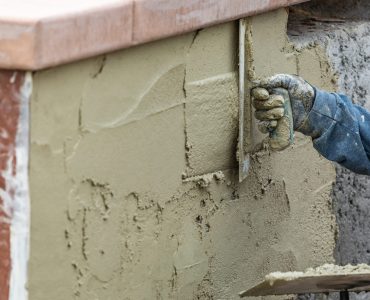 Tile Worker Applying Cement with Trowel at Pool Construction Site.