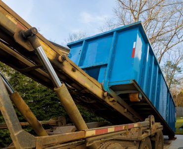 Unloading empty dumpster, recycle container view of new houses being built and construction garbage large container